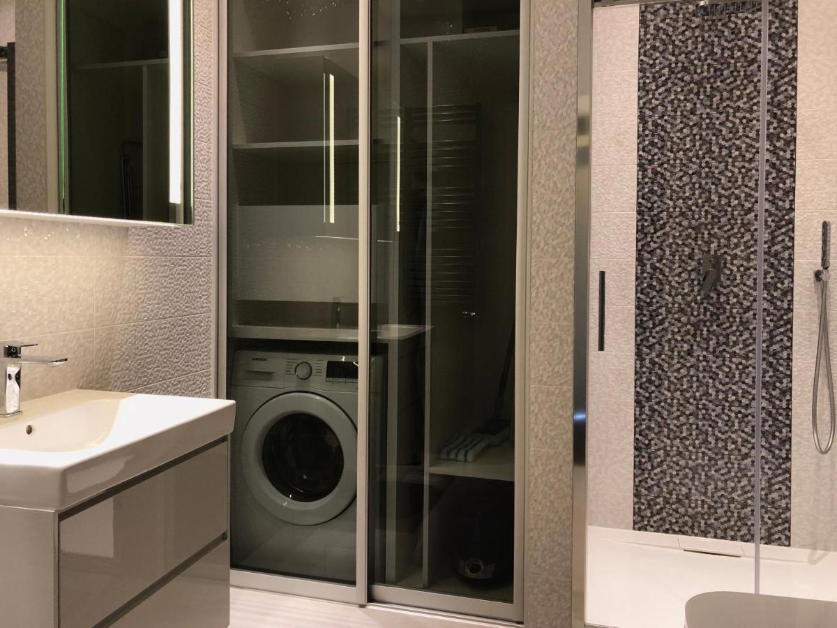 Łazienka z prysznicem i pralką — Apartament Neptun Park